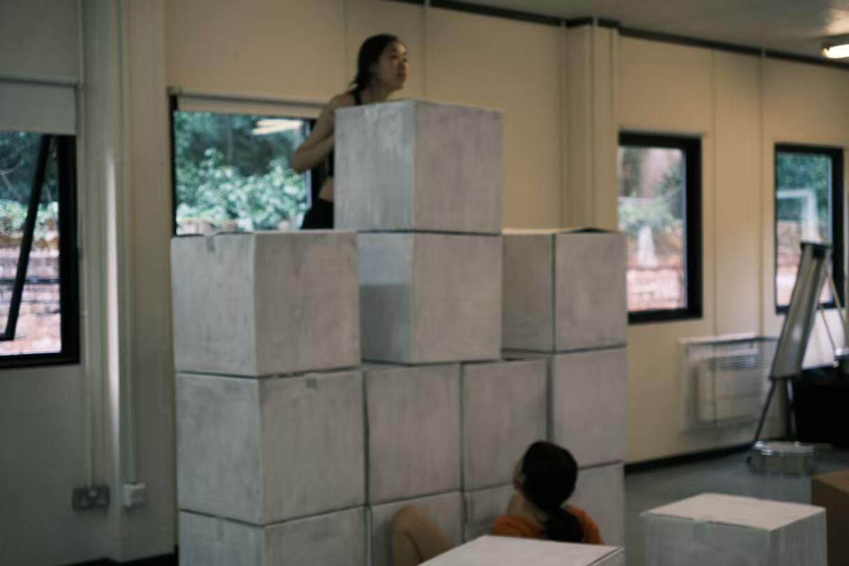 The production is staged inside a malfunctioning pixelated game world.